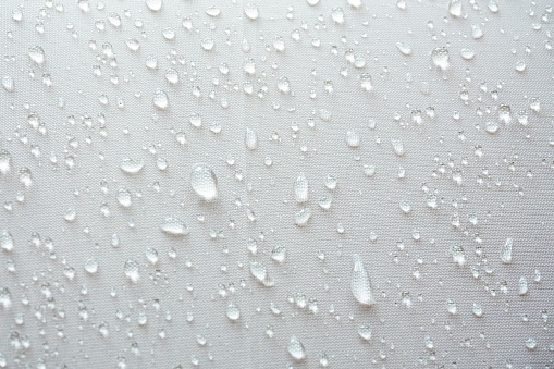 Water droplets on white textile, Moist rain drops on the surface of the umbrella