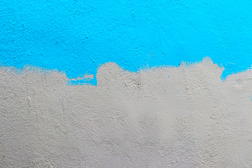 A wall half painted with blue colour.